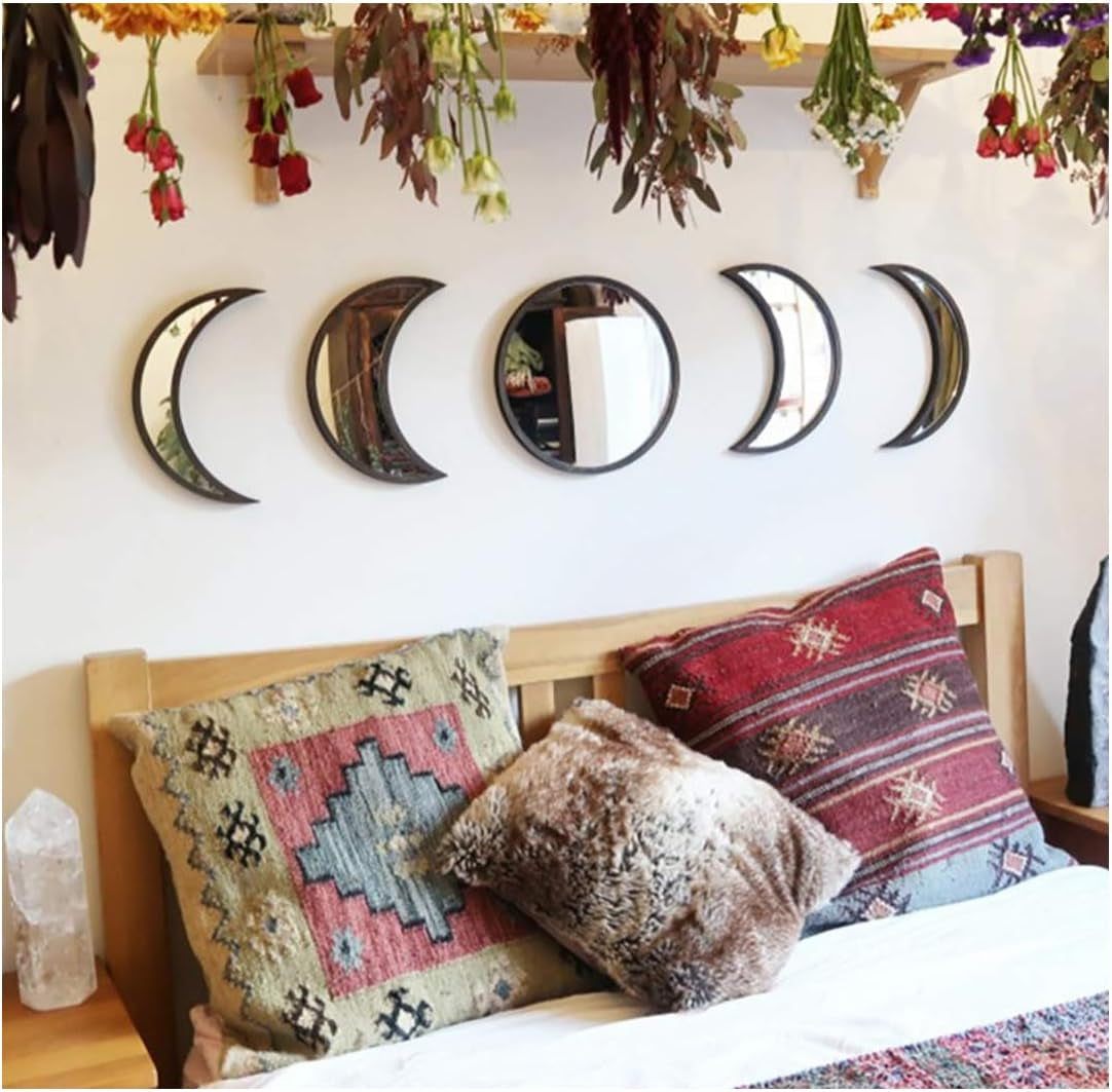 Scandinavian natural decor acrylic moon phase mirrors set on wall above bed with decorative pillows.